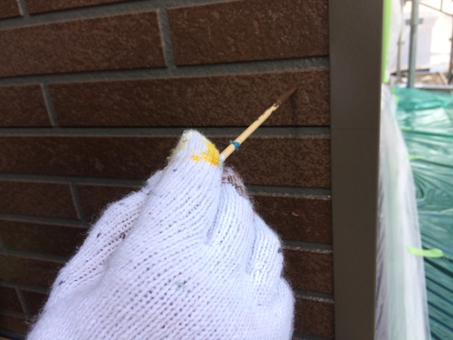 調色した塗料で釘跡を筆補修している様子