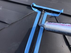 金属屋根の接合部にコーキング材を充填している様子