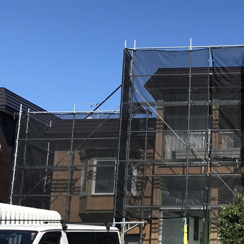 札幌市東区の塗装工事で足場と飛散防止ネットを設置した様子